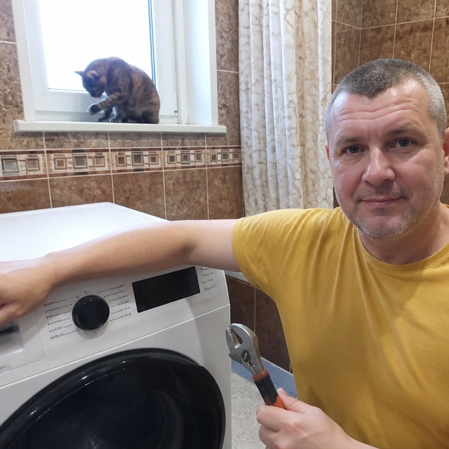 Мастер Александр рядом со стиральной машиной